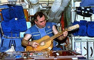 Mir-18 Gennadiy Strekalov plays the guitar in the Mir Core module during the Mir-18 mission.